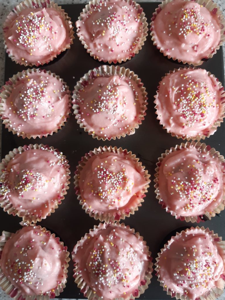 a tray of pink cupcakes