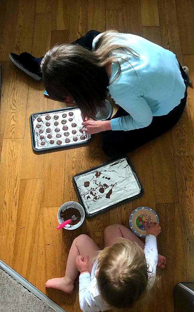mum and daughter sat on the floor decorating chocolate